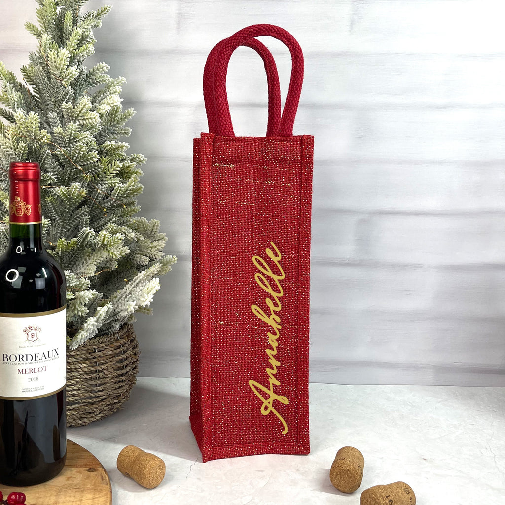 Red wine bottle bag with 'Annabelle' text next to a bottle of Bordeaux wine.