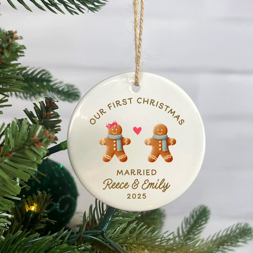 Personalized Christmas ornament with gingerbread men and text, hanging on a tree.