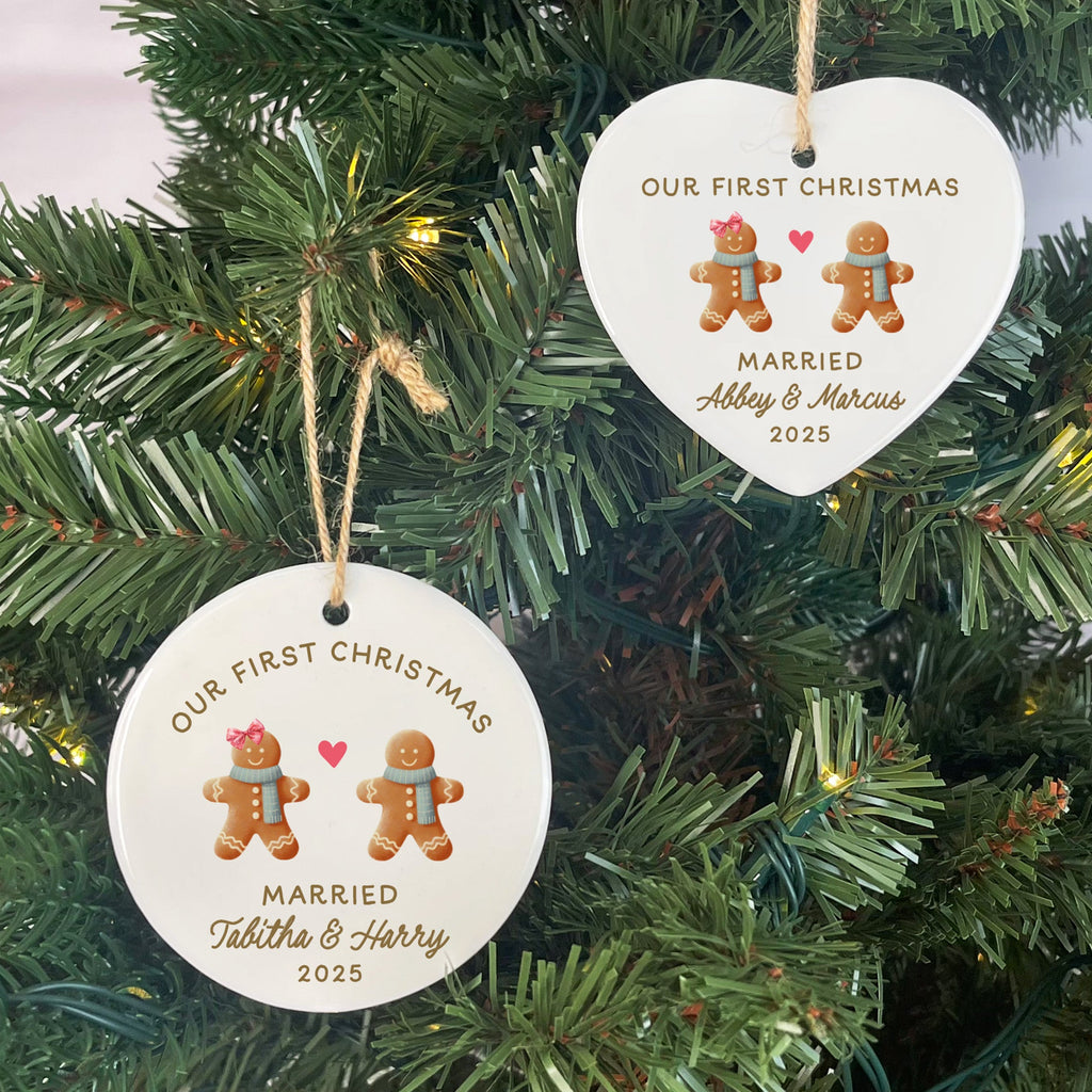 Two Christmas tree ornaments with 'Our First Christmas Married' text and gingerbread men design on a decorated tree.