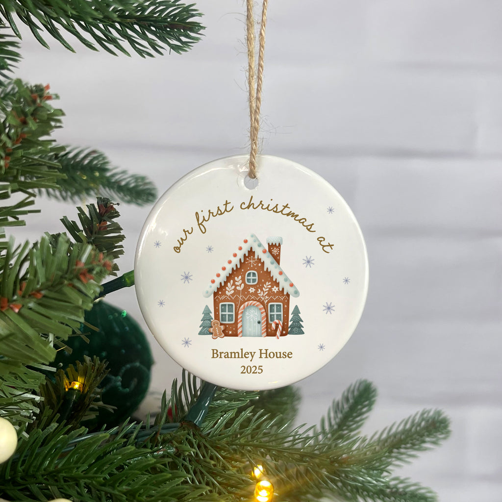 Decorative Christmas ornament with a gingerbread house design, hanging on a tree.