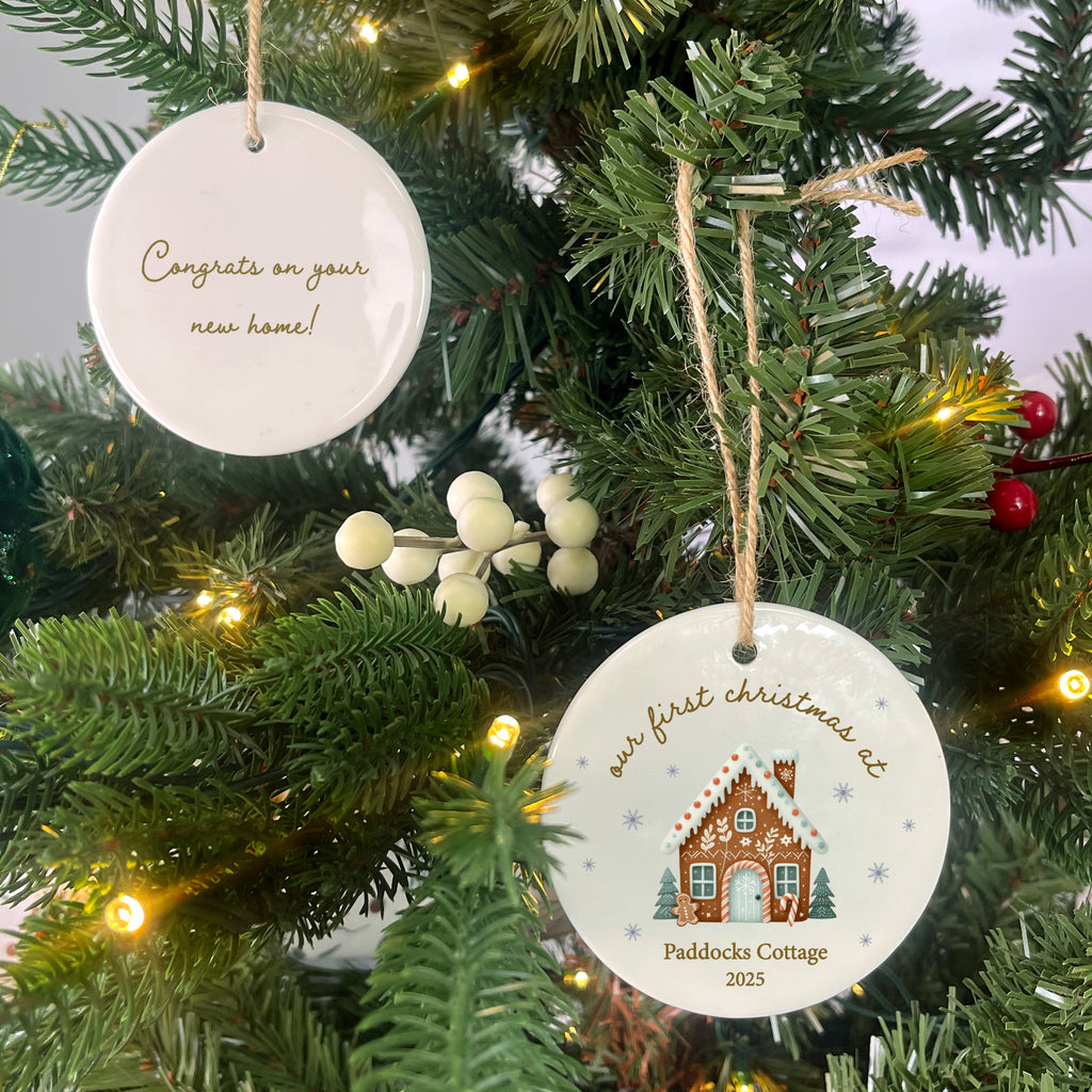 Two Christmas tree ornaments hanging on a decorated tree with lights.