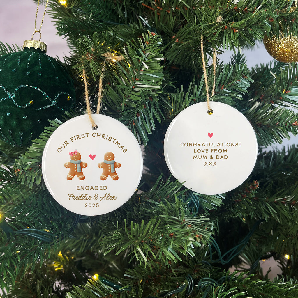 Two Christmas tree ornaments with personalized text on a decorated tree.