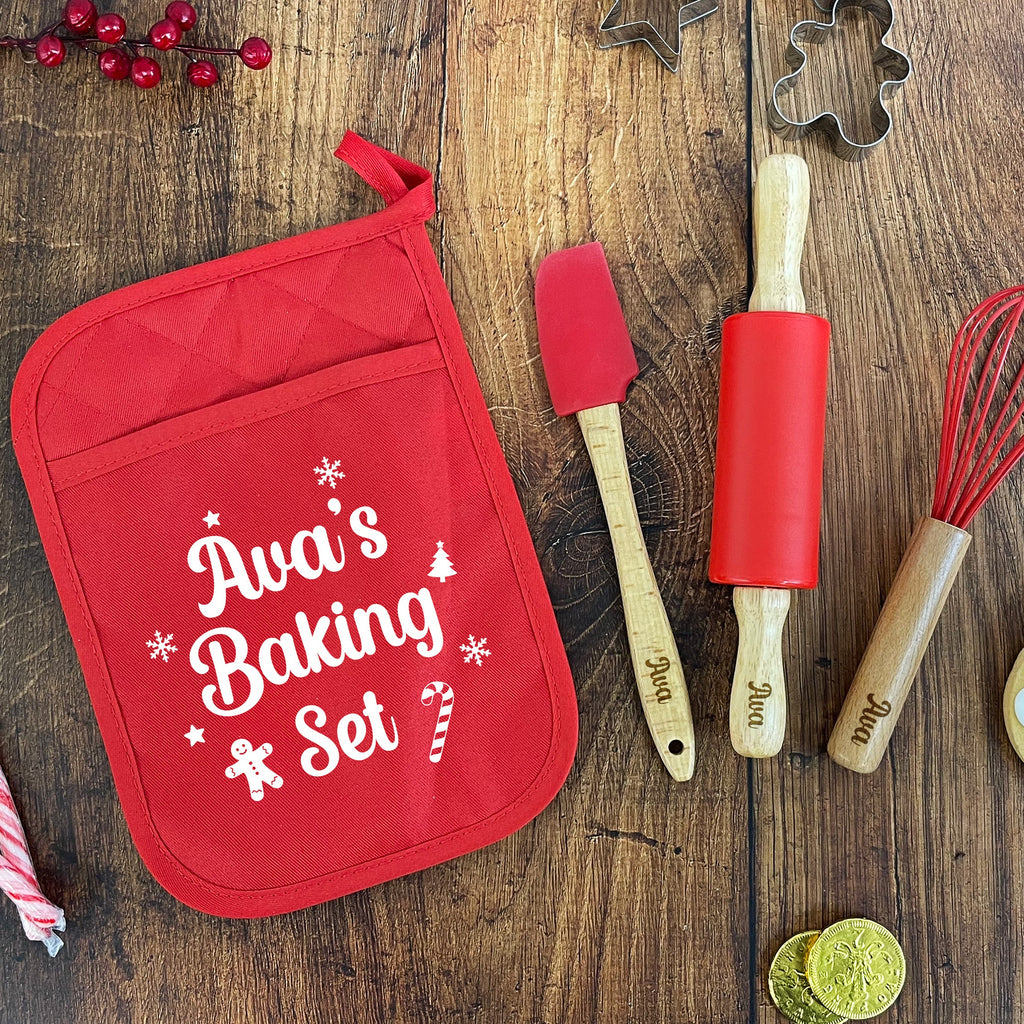 Red baking set with 'Ava's Baking Set' on a wooden surface with Christmas decorations.